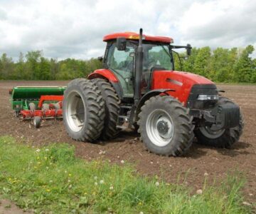 A red tractor plowing a field. A Red Tractor Plowing A Field.