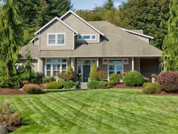 A home with a well-maintained lawn and trees in the front yard.