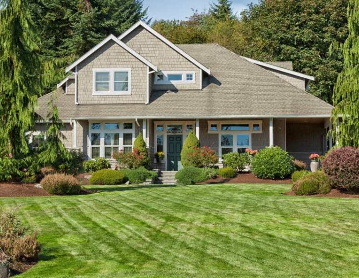 A home with a well-maintained lawn and trees in the front yard. A home with a well-maintained lawn and trees in the front yard.